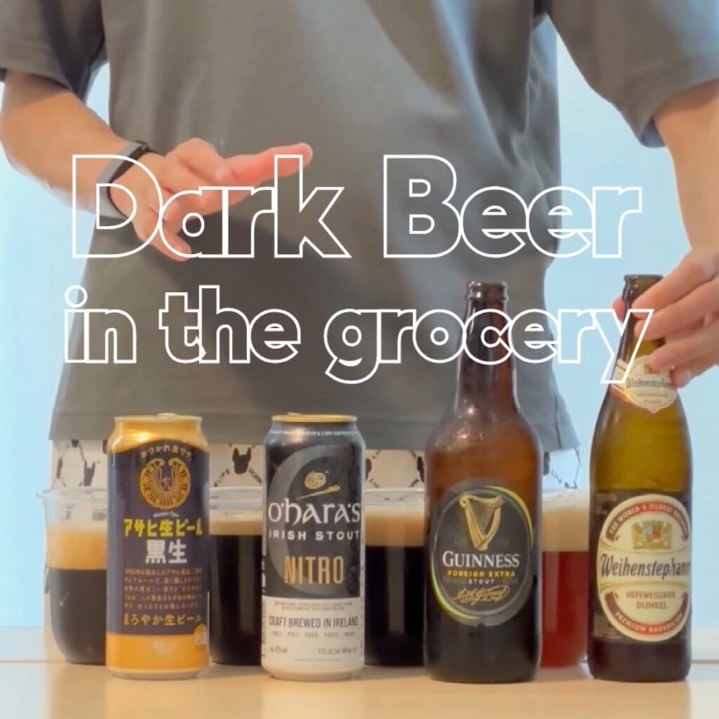 A grocery store aisle featuring a diverse selection of dark beers on the shelf, including stouts, porters, and dark lagers.